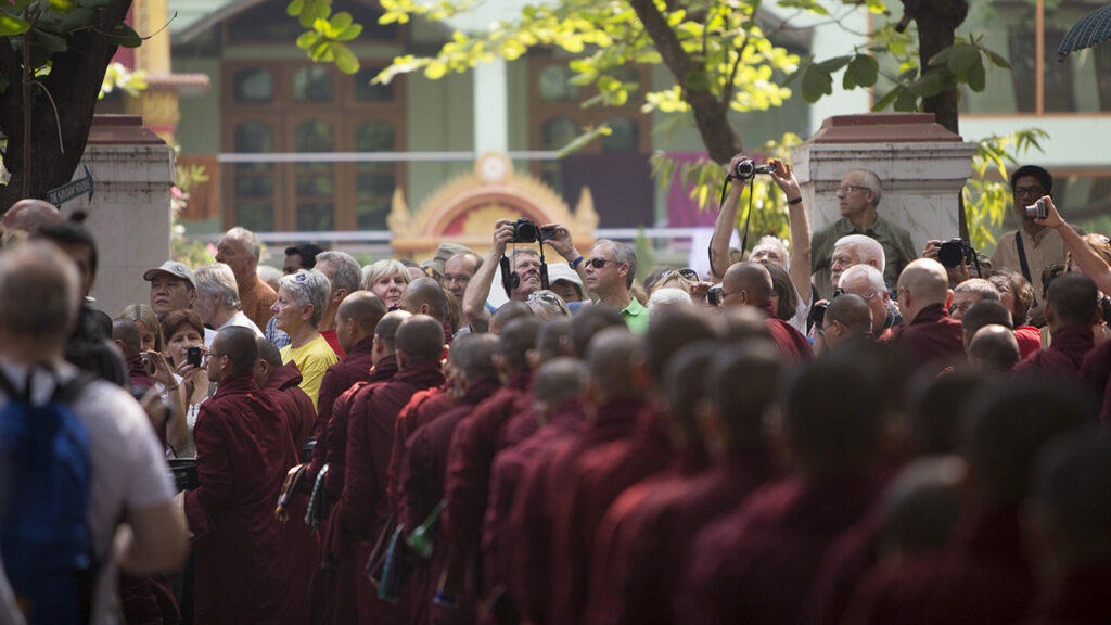 Mass tourism. Photo of tourists trying to get a glimpse at life as a monk in Myanmar.